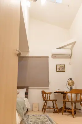 a living room with a table and a bed at 3 minutes walk to the station, direct to Ikebukuro, two-story house with a garden in Tokyo