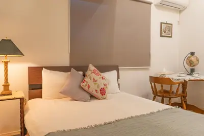 a bedroom with a bed with a lamp and a table at 3 minutes walk to the station, direct to Ikebukuro, two-story house with a garden in Tokyo