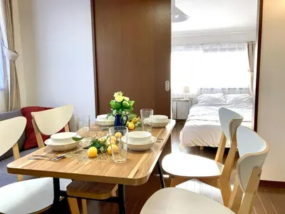a dining room with a table and chairs and a bed at AI-Daikannyama 201 in Tokyo