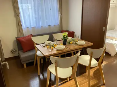 a dining room table and chairs with a table and a couch at AI-Daikannyama 201 in Tokyo