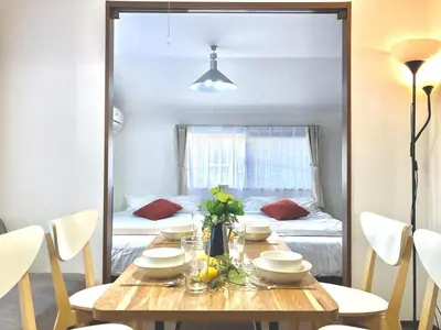 a dining room table with a mirror reflecting a bedroom at AI-Daikannyama 201 in Tokyo