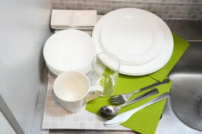 a kitchen counter with plates and cups and utensils at Shirokanedai guest suite in Tokyo