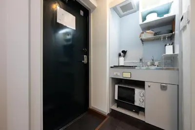 a black door in a kitchen with a sink at Shirokanedai guest suite in Tokyo