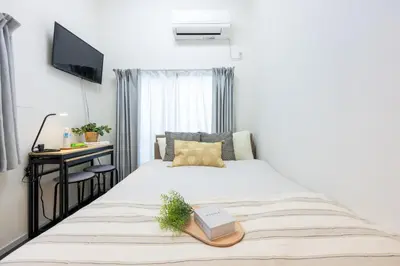 a bedroom with a bed with a book on it at Shirokanedai guest suite in Tokyo