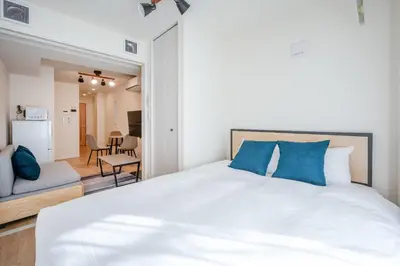 a bedroom with a large white bed with blue pillows at \u30d3\u30e5\u30fc\u30ceSumida in Tokyo