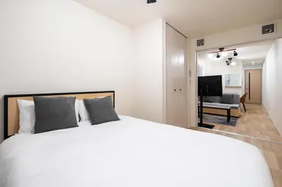 a bedroom with a white bed and a living room at \u30d3\u30e5\u30fc\u30ceSumida in Tokyo