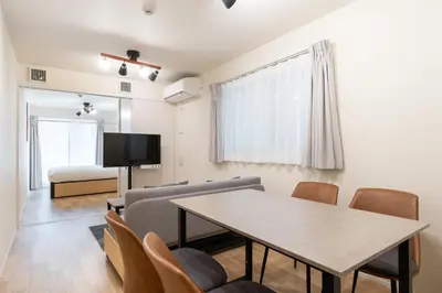 a living room with a table and chairs and a bed at \u30d3\u30e5\u30fc\u30ceSumida in Tokyo