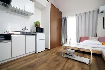 a living room with a bed and a kitchen at nakano202 in Tokyo