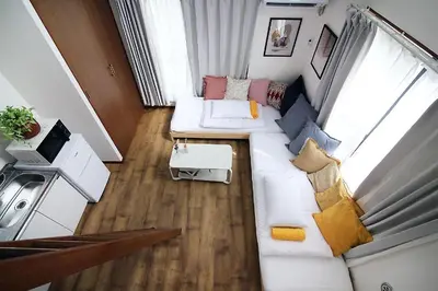 a living room with a white couch with pillows at nakano202 in Tokyo