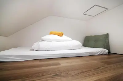 a bedroom with a white bed with a pillow on it at nakano202 in Tokyo