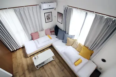 a living room with a white couch with colorful pillows at nakano202 in Tokyo