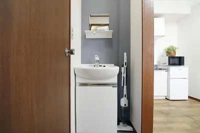 a bathroom with a white sink next to a door at nakano202 in Tokyo