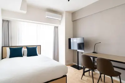 a bedroom with a bed and a desk and a television at \u30cf\u30a4\u30ea\u30fc\u30d5\u829d\u5927\u9580 in Tokyo