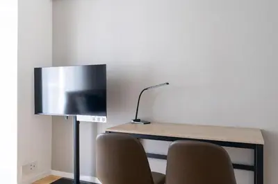 a desk with two chairs and a lamp and a television at \u30cf\u30a4\u30ea\u30fc\u30d5\u829d\u5927\u9580 in Tokyo