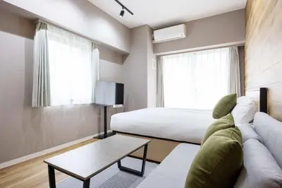 a hotel room with a bed and a couch and a table at \u30cf\u30a4\u30ea\u30fc\u30d5\u829d\u5927\u9580 in Tokyo