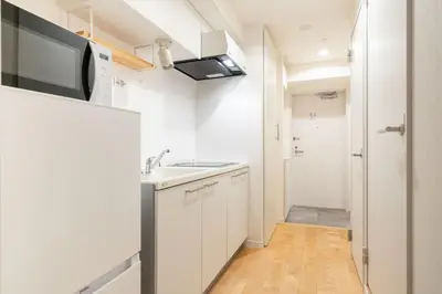a small white kitchen with a sink and a microwave at \u30cf\u30a4\u30ea\u30fc\u30d5\u829d\u5927\u9580 in Tokyo