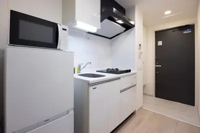 a kitchen with a sink and a microwave on a refrigerator at \u30ec\u30b8\u30c7\u30a3\u30a2\u4e2d\u843d\u5408a in Tokyo