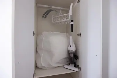 a white closet with a pillow and a white appliance at \u30ec\u30b8\u30c7\u30a3\u30a2\u4e2d\u843d\u5408a in Tokyo
