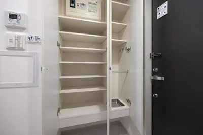 a walk in closet with white shelves and a door at \u30ec\u30b8\u30c7\u30a3\u30a2\u4e2d\u843d\u5408a in Tokyo