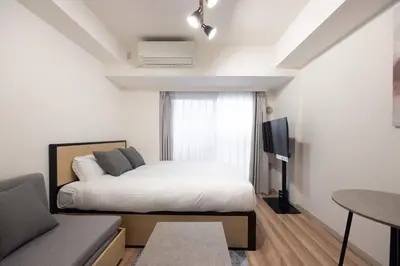 a bedroom with a bed and a tv and a couch at \u30ec\u30b8\u30c7\u30a3\u30a2\u4e2d\u843d\u5408a in Tokyo