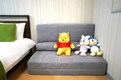 three stuffed animals are sitting on a gray chair at Room 202 Nishi-Shinjuku Gochome 9 minutes walk 40 square meters Sleeps up to 6 people in Tokyo