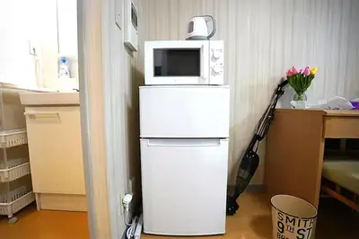 a microwave oven sitting on top of a refrigerator at Room 202 Nishi-Shinjuku Gochome 9 minutes walk 40 square meters Sleeps up to 6 people in Tokyo