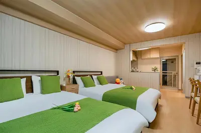 two beds in a room with green and white at Room 202 Nishi-Shinjuku Gochome 9 minutes walk 40 square meters Sleeps up to 6 people in Tokyo