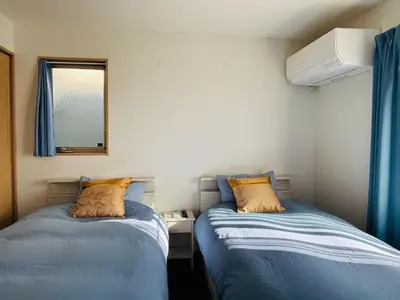 two beds in a room with blue sheets and a mirror at Lapis House - Vacation STAY 03045v in Tokyo