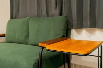 a table next to a green couch with a wooden table at Tokyo Skytree\u96fb\u8eca3\u5206 \u79cb\u8449\u539f\u307e\u30677\u5206 \u6d45\u8349\u6a4b\u307e\u30674\u5206 \u30ad\u30c3\u30c1\u30f3\u5b8c\u5099 \u9326\u7cf8\u753a\u99c5 \u5bdd\u5ba4\u4e8c\u3064 202\u90e8\u5c4b in Tokyo