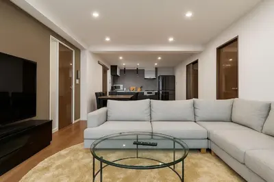 a living room with a white couch and a glass table at \u7af9\u5185\u30d3\u30eb in Tokyo