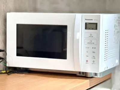 a white microwave oven sitting on top of a counter at \u7af9\u5185\u30d3\u30eb in Tokyo