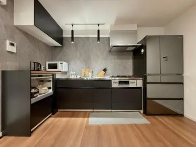 a kitchen with black cabinets and a microwave at \u7af9\u5185\u30d3\u30eb in Tokyo