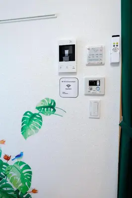 a wall with stickers of leaves and a microwave at Zenith Shinjuku Hinoki by Tranova in Tokyo