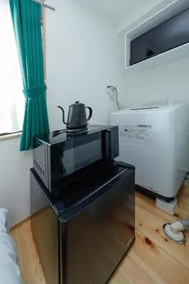 a microwave sitting on top of a table in a room at Zenith Shinjuku Hinoki by Tranova in Tokyo