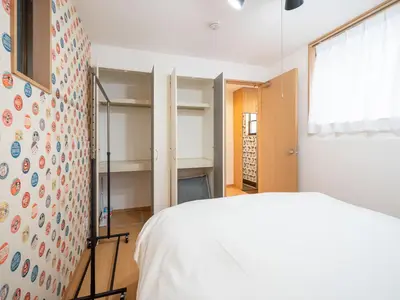 a bedroom with a bed and a wall with shelves at Familia Omorikaigan in Tokyo