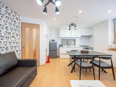 a living room with a table and chairs and a kitchen at Familia Omorikaigan in Tokyo