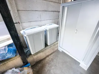 two white trash cans sitting next to a door at Familia Omorikaigan in Tokyo