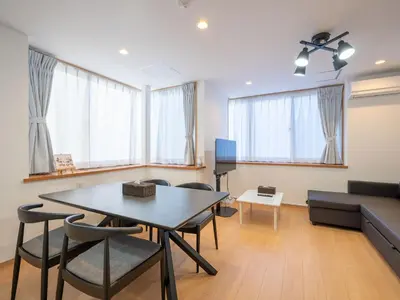 a living room with a table and chairs and a couch at Familia Omorikaigan in Tokyo