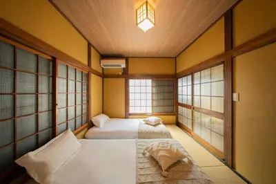 two beds in a room with two windows at \u65e5\u672c\u306e\u751f\u6d3b\u3092\u4f53\u9a13\u3067\u304d\u308b\u53e4\u6c11\u5bb6 \u4e00\u68df\u8cb8\u5207\u6700\u59277\u540d jr\u4e0a\u4e2d\u91cc\u99c5 in Tokyo