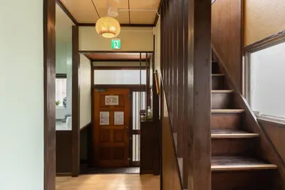 a hallway with stairs and a door with a sign on it at \u65e5\u672c\u306e\u751f\u6d3b\u3092\u4f53\u9a13\u3067\u304d\u308b\u53e4\u6c11\u5bb6 \u4e00\u68df\u8cb8\u5207\u6700\u59277\u540d jr\u4e0a\u4e2d\u91cc\u99c5 in Tokyo
