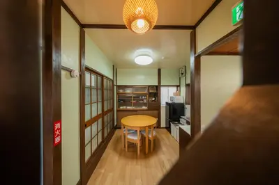 a small room with a table and a kitchen at \u65e5\u672c\u306e\u751f\u6d3b\u3092\u4f53\u9a13\u3067\u304d\u308b\u53e4\u6c11\u5bb6 \u4e00\u68df\u8cb8\u5207\u6700\u59277\u540d jr\u4e0a\u4e2d\u91cc\u99c5 in Tokyo