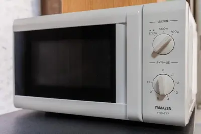 a white microwave oven sitting on top of a counter at \u65e5\u672c\u306e\u751f\u6d3b\u3092\u4f53\u9a13\u3067\u304d\u308b\u53e4\u6c11\u5bb6 \u4e00\u68df\u8cb8\u5207\u6700\u59277\u540d jr\u4e0a\u4e2d\u91cc\u99c5 in Tokyo