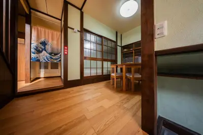 a room with wooden floors and a room with a table at \u65e5\u672c\u306e\u751f\u6d3b\u3092\u4f53\u9a13\u3067\u304d\u308b\u53e4\u6c11\u5bb6 \u4e00\u68df\u8cb8\u5207\u6700\u59277\u540d jr\u4e0a\u4e2d\u91cc\u99c5 in Tokyo