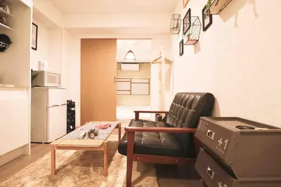 a living room with a leather chair and a coffee table at Cozy Japanese Room Near Skytree with Easy Airport Access in Tokyo