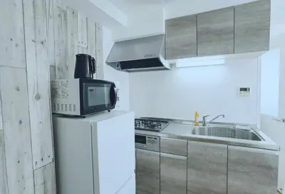 a microwave sitting on top of a refrigerator in a kitchen at #303WZNET\u6885\u5c4b\u6577\u99c52\u5206\u6a2a\u6d5c\u7fbd\u7530\u7a7a\u6e2f\u90fd\u5fc3\u4fbf\u5229\u5546\u5e97\u88571ldk\u5e83\u3044 in Tokyo