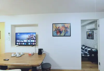 a living room with a table and a tv on the wall at #303WZNET\u6885\u5c4b\u6577\u99c52\u5206\u6a2a\u6d5c\u7fbd\u7530\u7a7a\u6e2f\u90fd\u5fc3\u4fbf\u5229\u5546\u5e97\u88571ldk\u5e83\u3044 in Tokyo