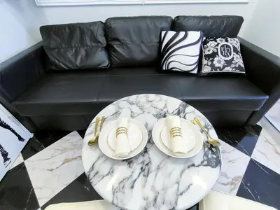 a black couch with a table with plates on it at S19\u65b0\u5bbf\u6700\u4e2d\u5fc3 \u6b4c\u821e\u4f0e\u753a \u6771\u65b0\u5bbf\u7ad95\u5206 3\u5ba41\u5385 \u6700\u59277\u4eba-Shinjuku center 3 rooms 5 mins to St, Max 7P \u76f4\u8fbe\u65b0\u5bbf \u6d89\u8c37 \u8868\u53c2\u9053 \u6c60\u888b \u4e0a\u91ce \u4ee3\u4ee3\u6728 \u94f6\u5ea7 \u539f\u5bbf in Tokyo