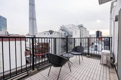 a balcony with two chairs and a view of a city at Wasabi Sky Oshiage \u62bc\u4e0a\u99c5\u5f92\u6b69\u30a2\u30d1\u30fc\u30c8 in Tokyo