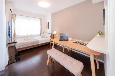 a room with a bed and a desk with a laptop at Wasabi Sky Oshiage \u62bc\u4e0a\u99c5\u5f92\u6b69\u30a2\u30d1\u30fc\u30c8 in Tokyo