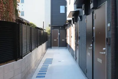 an alleyway between two buildings with doors on the side at Flora Maison Kamiochiai by Tranova in Tokyo